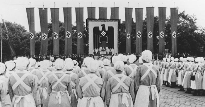 The image shows dozens of nurses swearing their allegiance to the German Red Cross at an induction ceremony in Nuremberg in June 1940.